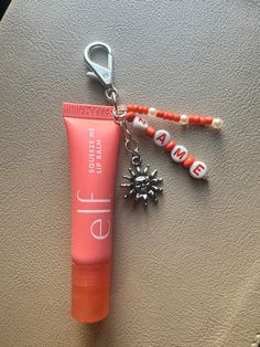 an orange tube and keychain are sitting on a car seat next to a sun charm