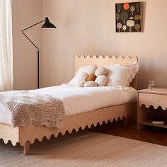 a bed with white sheets and pillows on top of it next to a lamp in a room