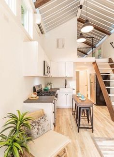 an open concept kitchen and living room with stairs leading up to the second floor area