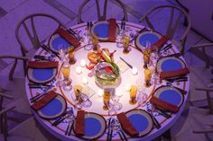 an overhead view of a table set with place settings and flowers on the centerpiece