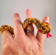 a hand holding a ring made out of yarn