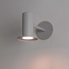 a white wall light mounted on the side of a wall