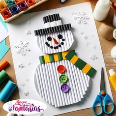 a snowman made out of strips of paper next to crayons and scissors