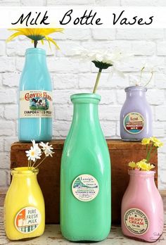 three different colored vases with flowers in them