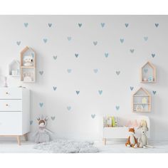 a child's room with blue heart wall decals on the walls and a white dresser