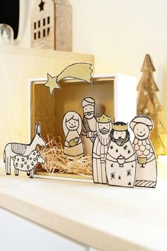 a wooden nativity scene in a box on a mantle