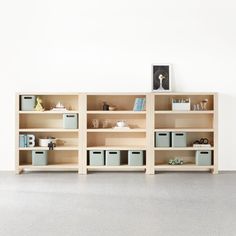 an empty room with several wooden shelves and bins on the floor next to each other