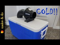 a cooler sitting on top of a counter next to a blue and white sign that says cold