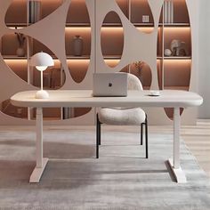 a laptop computer sitting on top of a white table in front of a book shelf