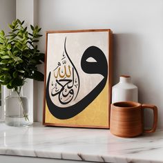 an arabic calligraphy is displayed on a shelf next to a vase and potted plant