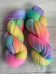 two skeins of multicolored yarn sitting on top of each other