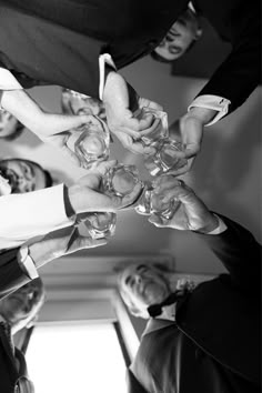 a group of people standing around each other holding wine glasses