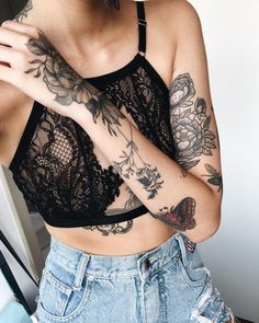 a woman with tattoos on her arm and chest