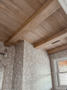 a bathroom with wood ceiling and wall paper