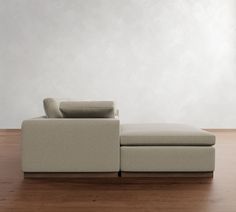 a couch sitting on top of a wooden floor next to a white wall in an empty room