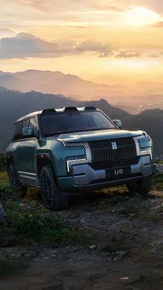 a green suv parked on the side of a mountain at sunset with mountains in the background