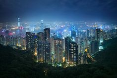 the city is lit up at night with bright lights on it's skyscrapers