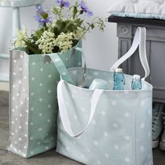 two polka dot bags are sitting on the floor next to each other with bottles in them