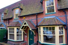 two story brick building with white windows and green door