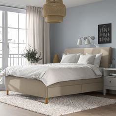 a bedroom with a bed, nightstands and two lamps on either side of the bed