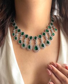 Adorn yourself in resplendent elegance with our Emerald green CZ Necklace Set, a dazzling fusion of sophistication and allure.   Encased in a lustrous setting, each crystal reflects light with mesmerizing brilliance, ensuring all eyes are drawn to its radiant beauty.  Perfect for weddings or any special occasion, this Indian-inspired statement necklace exudes timeless charm and grace, making every moment a cherished memory. Elevate your ensemble and enchant onlookers with this enchanting American Diamond Necklace, a testament to refined taste and elegance  Necklace length-15 inches  Width-8.5"  Adjustable length Necklace Closure: Hook Earrings length :1.5" Each earring weighs 5gms Earrings Closure: Pushback Diamond Necklace Indian, American Diamond Necklaces, Necklace Indian, Indian Necklace, Indian Jewelry Sets, Bollywood Jewelry, Pakistani Jewelry, Cz Necklace, Jewelry Indian