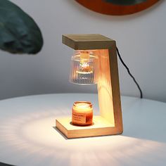 a small wooden table lamp with a jar on it