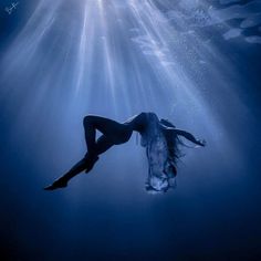 a woman is floating in the water with her legs spread out and head above the water's surface