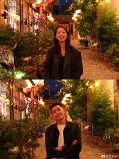 a man and woman standing in front of some plants on the side of a building