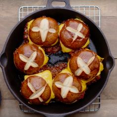 hot dogs in buns with cheese on them sitting in a cast iron skillet