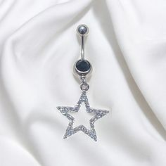 a silver star belly button ring on white fabric