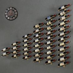 a wall with many bottles of wine on it and a clock in the back ground