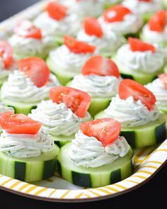 cucumber bites with cream cheese and tomatoes on them are ready to be eaten