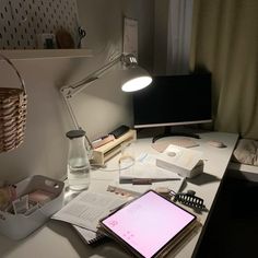 the desk is cluttered with books, papers, and a tablet computer on it