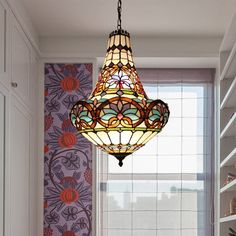 a stained glass chandelier hangs in the corner of a room with colorful wallpaper