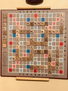 a scrabble board with words on it and a clock mounted to the wall