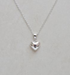 "A super shiny sterling silver puffed heart is suspended from a shimmery sterling silver chain....simple and delicate - great for everyday! ✩ Sterling silver heart pendant is 0.5\". ✩ 1.5mm rolo chain is finished with a high-quality spring ring clasp to form the closure. All chain components are 925 sterling silver. Total length is end-to-end including all clasps. If you would like a length other than what is listed, simply choose the closest and leave us a note at checkout. ✩ Personalize it here: http://etsy.me/2zhF3rc ✩ Comes beautifully packaged as shown in a branded box with care instructions. If this is intended as a gift, please let us know when you check out...that way we can include a blank gifting card for you! ~ More heart jewelry: http://etsy.me/1ttcC4g ~ Please be sure to read Luxury Sterling Silver Charm Necklace With Heart Pendant, Heart Jewelry Silver, Silver Dainty Heart Necklace, Dainty Silver Heart Necklace, Simple Silver Heart Pendant Necklace, Pretty Jewellery Silver, Puffy Heart Necklace, Silver Heart Jewelry, Heart Necklace Silver