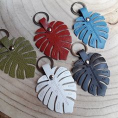 four leather keychains with monster leaves on them