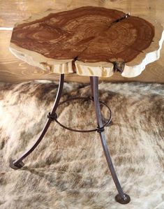 a wooden table sitting on top of a fur covered floor next to a metal frame