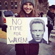 a woman holding up a sign that says no time for walkin on the street