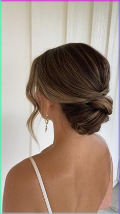 the back of a woman's head, with her hair in a low bun