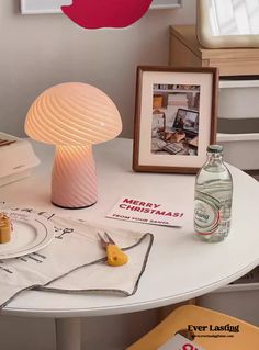 a table topped with a lamp next to a bottle of water and other items on top of it