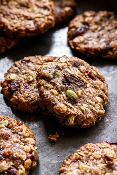 several cookies with nuts and raisins sitting on top of a baking sheet, ready to be eaten