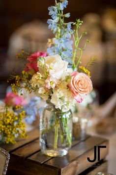 a vase filled with flowers sitting on top of a wooden table