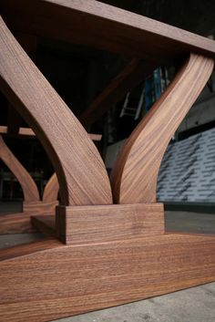 a close up of a wooden table with an unusual design on it's base