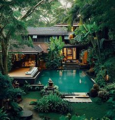 an outdoor pool surrounded by greenery and trees in the middle of a garden area