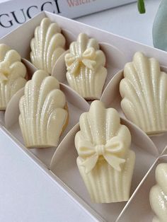 six white chocolates in a box with a bow on the front and back side