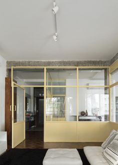 a living room filled with white furniture and lots of glass doors to the outside area