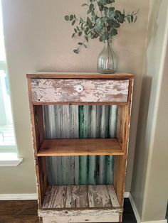 a wooden shelf sitting next to a vase filled with flowers