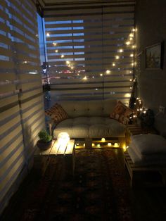 a living room filled with furniture and lots of lights on the window sill above it