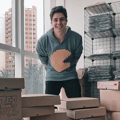 a man standing in front of boxes with a heart on it's shirt that is made out of cardboard